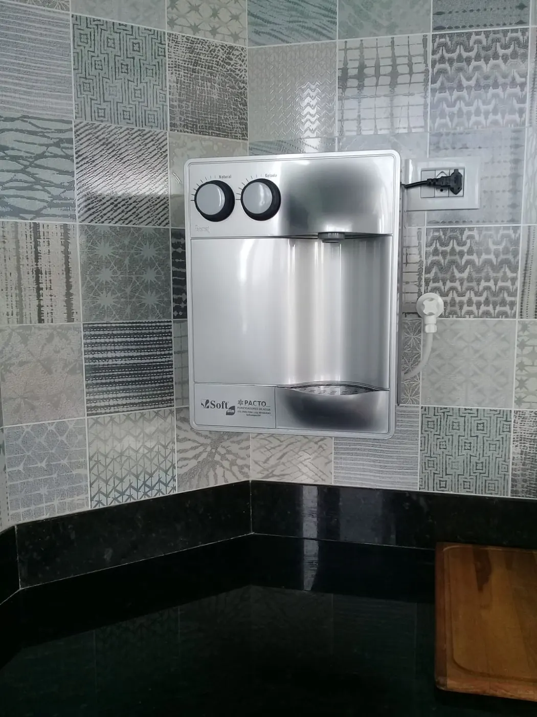 Purificador de água Soft Slim prata instalado em parede de azulejos estampados cinza