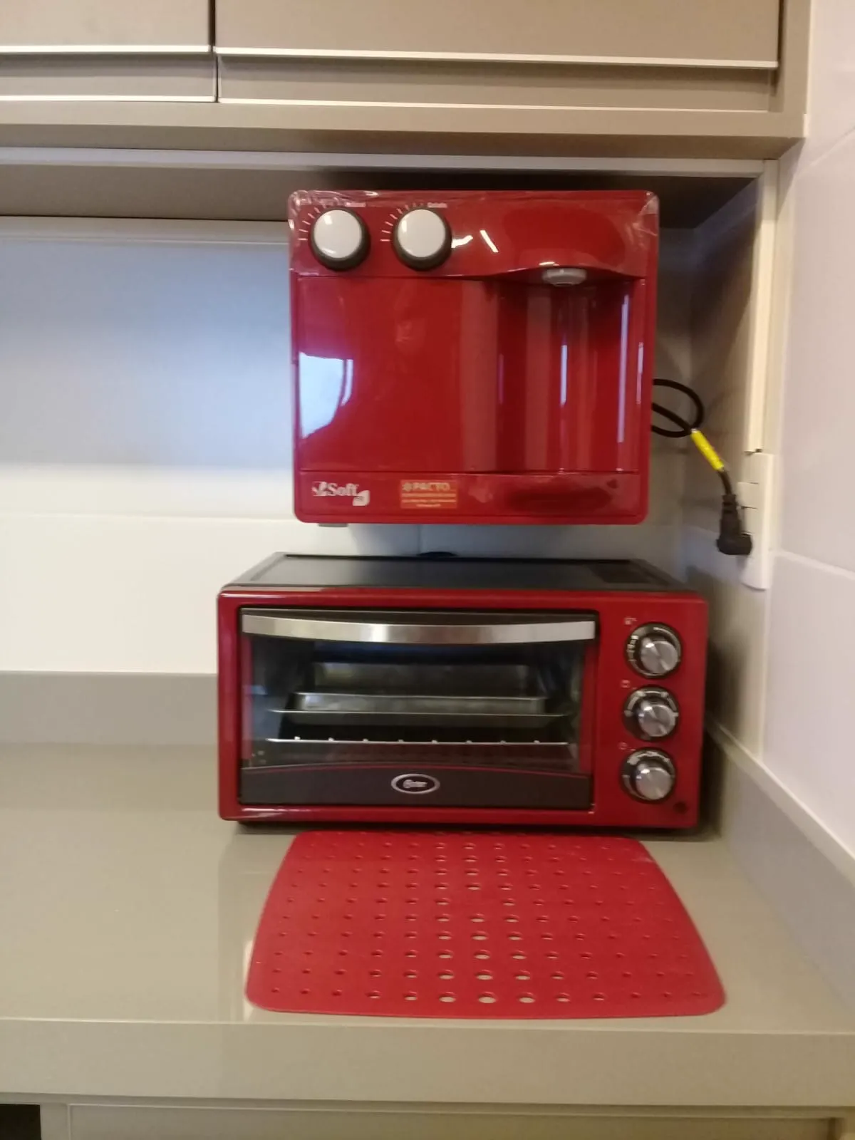 Purificador de água vermelho instalado em nicho de armário planejado